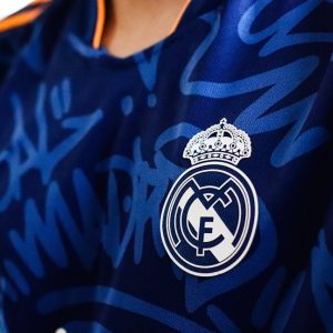Detailed view of a blue soccer jersey featuring a prominent club emblem, ideal for sports branding.